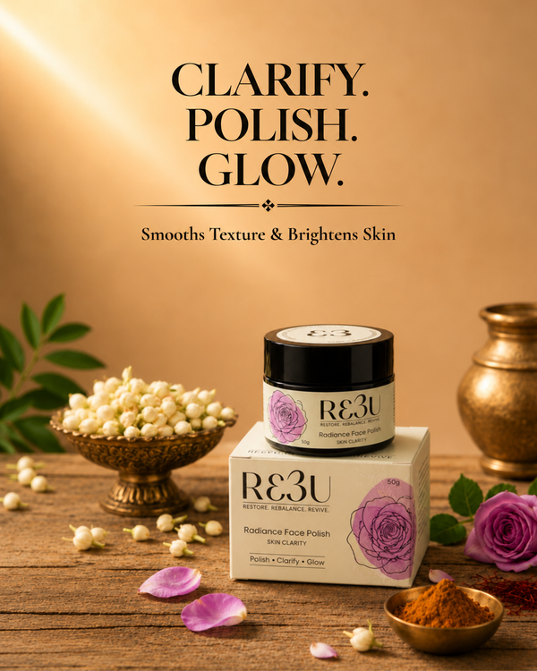 R3U Radiance Face Polish in a black jar with a purple rose label, displayed on top of its cream-colored box. The product is styled on a rustic wooden table with decorative props including jasmine flowers, rose petals, turmeric, and a brass pot, set against a warm golden background with promotional text.